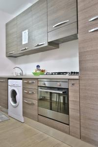 uma cozinha com um fogão e uma máquina de lavar roupa em Appartamento sole&mare em Levanto