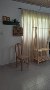 einen Stuhl und einen Tisch in einem Zimmer mit Fenster in der Unterkunft Monoambiente pequeño in Carmen de Patagones