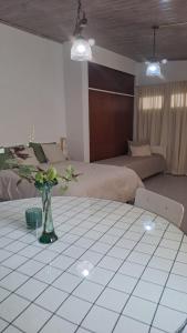 ein Zimmer mit einem Bett und einem Tisch mit Blumen darauf in der Unterkunft Monoambiente pequeño in Carmen de Patagones