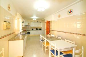 a kitchen with a white table and chairs in it at Olival Beach Villa with Pool walking distance to Beach in Armação de Pêra