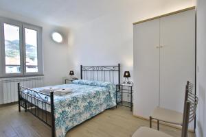 um quarto com uma cama, uma cadeira e um espelho em Appartamento sole&mare em Levanto
