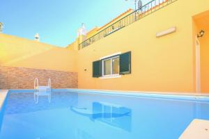a swimming pool in front of a house at Olival Beach Villa with Pool walking distance to Beach in Armação de Pêra