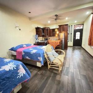 a bedroom with a bed and a chair and a kitchen at Apartamento Jacob in San Pedro La Laguna