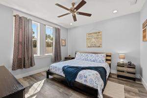 une chambre avec un lit et un ventilateur de plafond dans l'établissement Sandy Palms - Pool & Hot Tub, 3 Min Walk to the Beach, w Golf Cart & Beach Gear, à Panama City Beach 46 autres photos