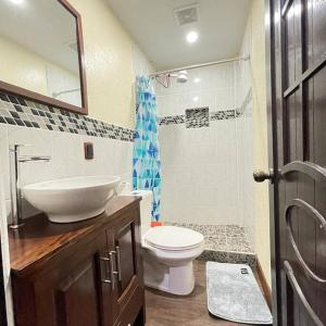 y baño con lavabo, aseo y espejo. en Apartamento Jacob en San Pedro La Laguna