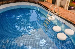una piscina con suelo de baldosa azul y un columpio en Sunset Hostel, en La Paz
