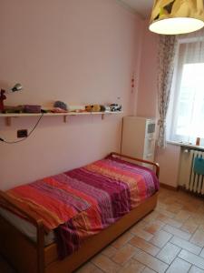 Un dormitorio con una cama con una manta de colores. en Appartamento Il Cedro en Rosia