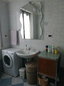 La salle de bains est pourvue d'un lavabo et d'un lave-linge. dans l'établissement Appartamento Il Cedro, à Rosia