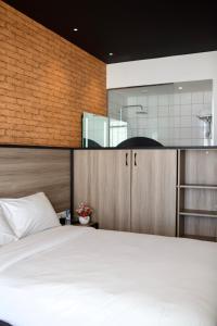 a bedroom with a large white bed and a kitchen at ONOMO Hotel Tanger Med in Tangier