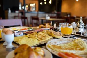 a table topped with plates of breakfast foods and orange juice at ONOMO Hotel Tanger Med in Tangier