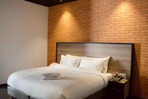 a large bed in a room with a brick wall at ONOMO Hotel Tanger Med in Tangier