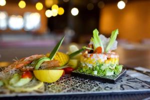 a plate of food with sushi and vegetables on a table at ONOMO Hotel Tanger Med in Tangier