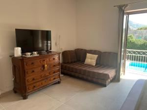 a living room with a couch and a tv and a dresser at Domus Orestea Luxury Suites in Palermo