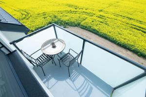 a balcony with a table and chairs and a field at Apartmán Sunset View in Skalica