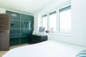 1 dormitorio con 1 cama, vestidor y ventanas en Apartmán Sunset View, en Skalica