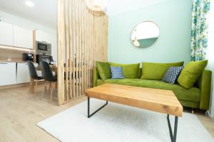 een woonkamer met een groene bank en een tafel bij Apartmán Sunset View in Skalica