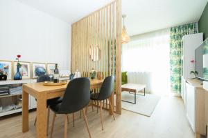 a dining room with a wooden table and chairs at Apartmán Sunset View in Skalica