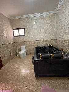 a bathroom with a black tub and a toilet at Haramous Guest House in Djibouti