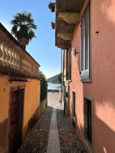 un callejón entre dos edificios con una palmera en Casa Anita, en Mergozzo