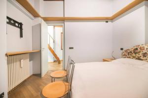 1 dormitorio con 1 cama blanca y 2 sillas en Casa Anita, en Mergozzo