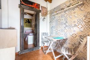 Cette chambre comprend un miroir, une table et une chaise. dans l'établissement Cottage degli acquedotti, à Rome