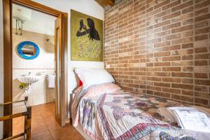 - une chambre aux murs en briques avec un lit dans l'établissement Cottage degli acquedotti, à Rome