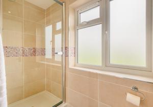 ein Bad mit einer Dusche und einem Fenster in der Unterkunft 2 The Homestead in Frostenden