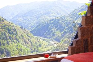 a view of a mountain valley from a bedroom window at Dastavi Dağ Evleri in Çamlıhemşin