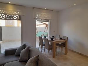 a living room with a couch and a table with chairs at Nayah Stays, Beautiful 3-bedroom vacation home with lovely pool in Hurghada