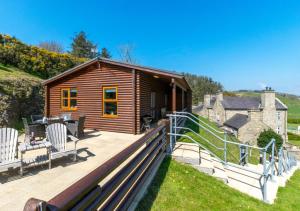 a wooden cabin with two chairs on a deck at Gorwel in Abersoch