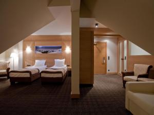 pokój hotelowy z dwoma łóżkami i kanapą w obiekcie Grand Nosalowy Dwór w Zakopanem