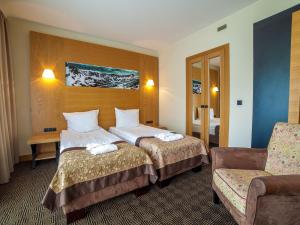 pokój hotelowy z dwoma łóżkami i krzesłem w obiekcie Grand Nosalowy Dwór w Zakopanem +37 zdjęć