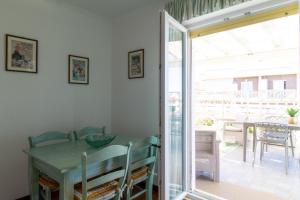 a dining room with a table and a sliding glass door at Attico Centralissimo Vista Mare in Torvaianica