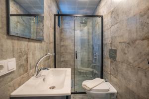 een badkamer met een douche, een wastafel en een toilet bij TAYLA SUİT in Kas