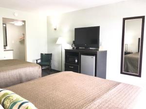 a hotel room with two beds and a flat screen tv at Ocean Plaza Motel in Myrtle Beach