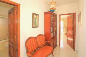 uma sala de estar com uma cadeira laranja num quarto em Olival Beach Villa with Pool walking distance to Beach em Armação de Pêra