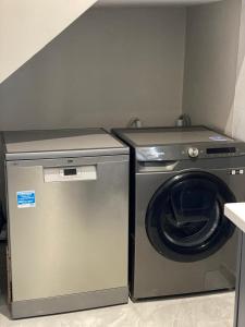 a washing machine and a washer in a room at modern, two-story luxury house in Gaborone