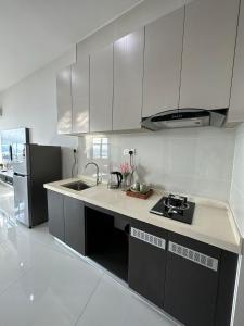 a white kitchen with a sink and a stove at Beach Apartment @ Country Garden Danga Bay in Johor Bahru