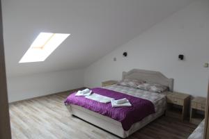 a bedroom with a bed with purple sheets and towels at Panorama view apartment VANJA in Baošići +17 photos