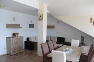a dining room and living room with a table and chairs at Panorama view apartment VANJA in Baošići