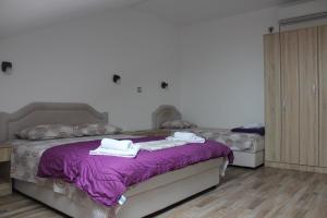 a bedroom with two beds with purple sheets and towels at Panorama view apartment VANJA in Baošići