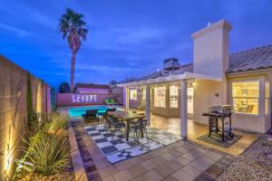 a house with a patio with a table and chairs at Sunset Swim - Modern Vegas Heated Pool Retreat in Las Vegas