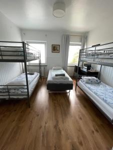 a bedroom with two bunk beds and a wooden floor at Grums Old House in Grums