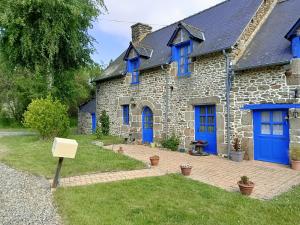 a stone house with blue doors and a yard at Roulottes des Trolls in La Boussac