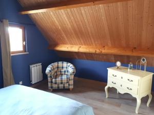 a bedroom with blue walls and a bed and a chair at LE CHALET in Saint-Pierre-dʼArthéglise