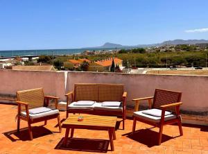 trzy krzesła i stół na patio z widokiem w obiekcie La Perla Del Puerto w mieście Gandía