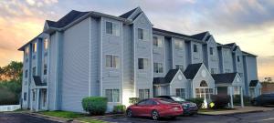 a large house with a red car parked in front of it at Microtel Inn & Suites by Wyndham Tulsa - Catoosa Route 66 in Tulsa