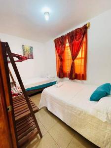 een slaapkamer met 2 bedden en een raam bij Apartamentos Jasmin in San Pedro La Laguna