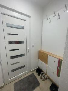 Zimmer mit weißer Tür und einigen Schuhen in der Unterkunft Chill Apartment in Sarajevo