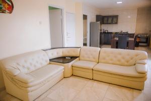 una sala de estar con 2 sofás de cuero blanco en Happy Holidays Style Residences, en Paramaribo
